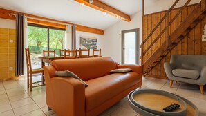 Un salon moderne avec un canapé, un fauteuil gris, une table basse et un escalier.