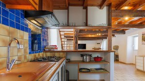 Une cuisine dotée d’un plan de travail en bois, d’un évier en acier inoxydable et d’une cuisinière.