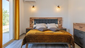 Ein Schlafzimmer mit einem Bett, Nachttischen, einem Holzkopfteil und zwei Wandleuchten.