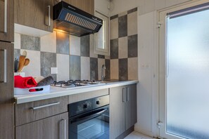 Una cocina moderna con estufa a gas, horno y ventana.