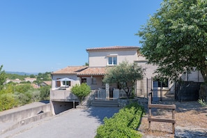 A two-story house with a tiled roof, a front porch, and a fenced yard. - Gîte Barbouillet – Village of Cottages (Joyeuse)