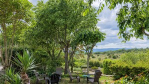 Un jardin avec des sièges extérieurs, une table et un panneau indiquant une zone Wi-Fi.