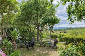 Un jardin avec des sièges extérieurs, une table et un panneau indiquant une zone Wi-Fi.