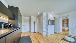 A modern apartment with a kitchen, a living area, and a bedroom. - Apartment with a view of the surrounding mountains (Pfalzen)
