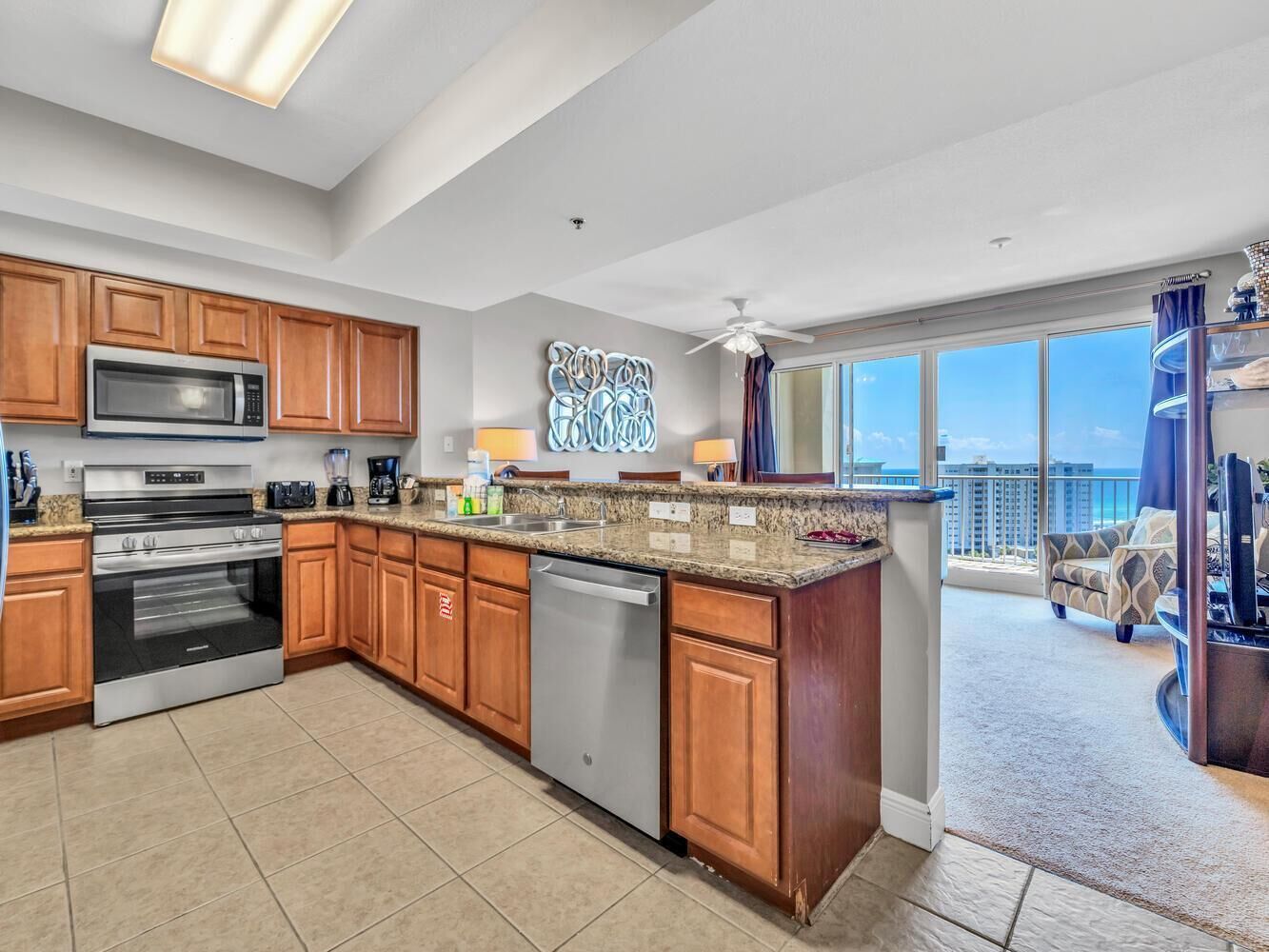 A modern kitchen with wooden cabinets, stainless steel appliances, and a large island.
