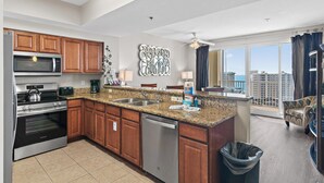 A modern kitchen with granite countertops, stainless steel appliances, and wooden cabinets. - Ariel Dunes II 1305 (Miramar Beach)