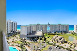 Um hotel com um edifício central imponente, piscina e vista para o oceano.