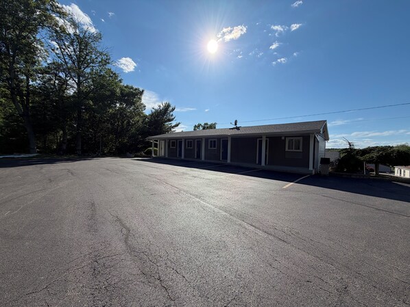 A motel with a parking lot, a single-story building, and a clear sky. - Chaplin Inn & Suites (Chaplin)