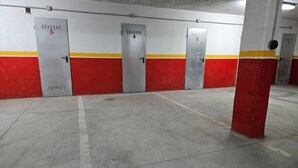 A parking garage with concrete floors and red and white walls, featuring doors numbered 3, 4, and 5. - 21A02 Charming Apartment with Garage by R2R (Aller)