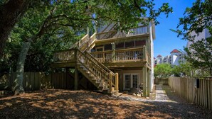 A two-story wooden house with a wooden deck and a staircase leading to the upper level. - Pet Friendly! Ocean Views/2 king suites/ sleeps 12 (North Topsail Beach)