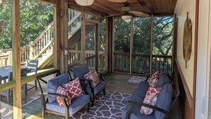 A covered outdoor seating area with wooden furniture and a ceiling fan. - Pet Friendly! Ocean Views/2 king suites/ sleeps 12 (North Topsail Beach)