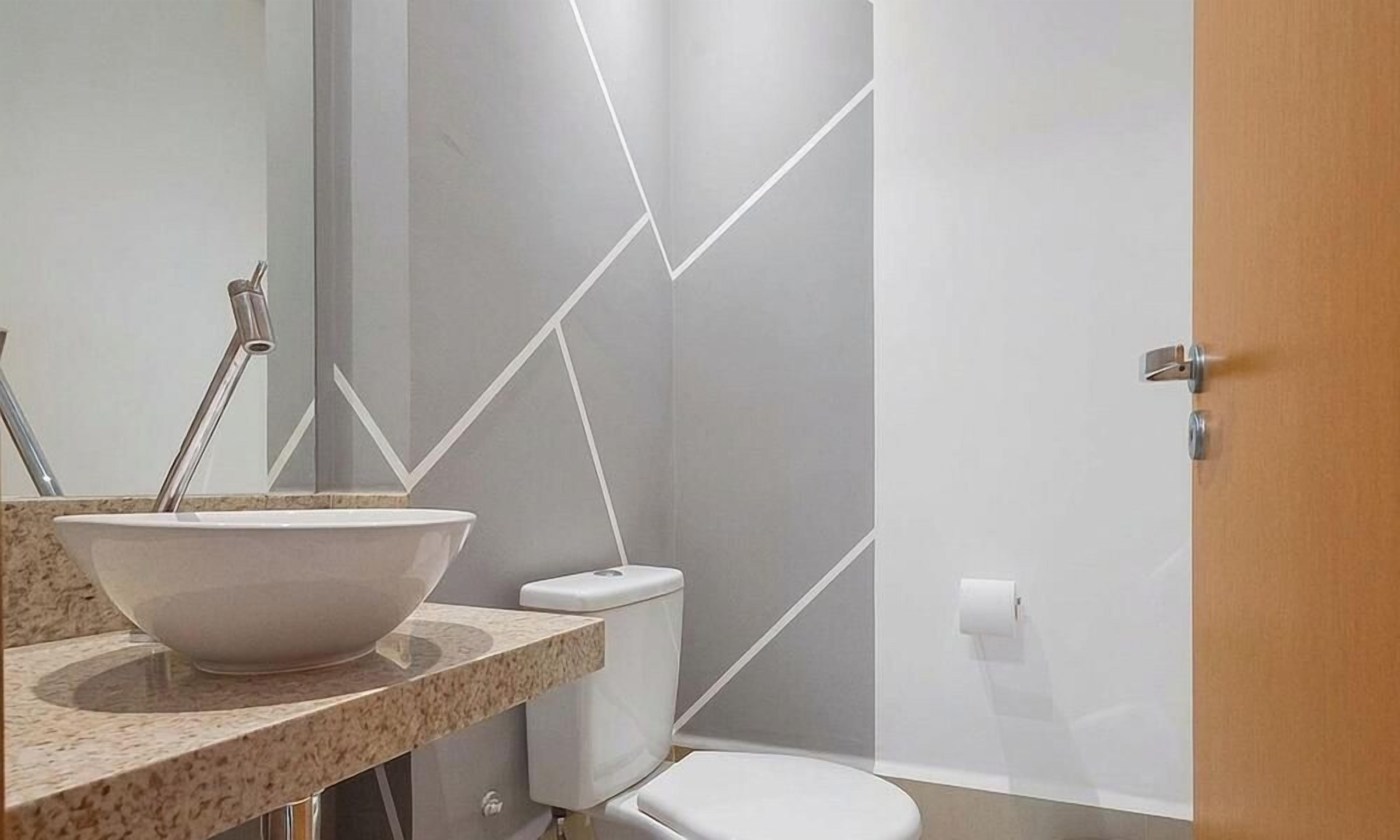 Un baño moderno con lavamanos blanco, inodoro y zona de ducha.