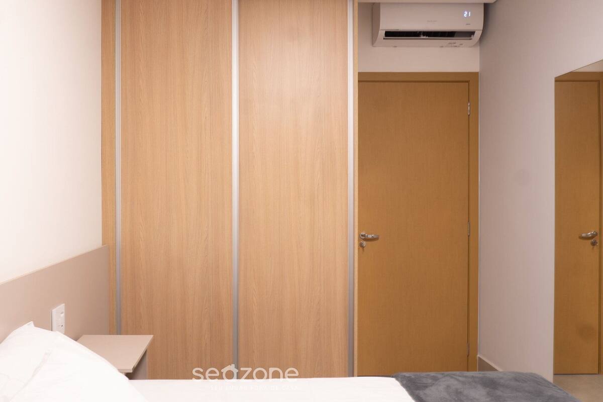 Un dormitori amb un llit, un armari i una porta.