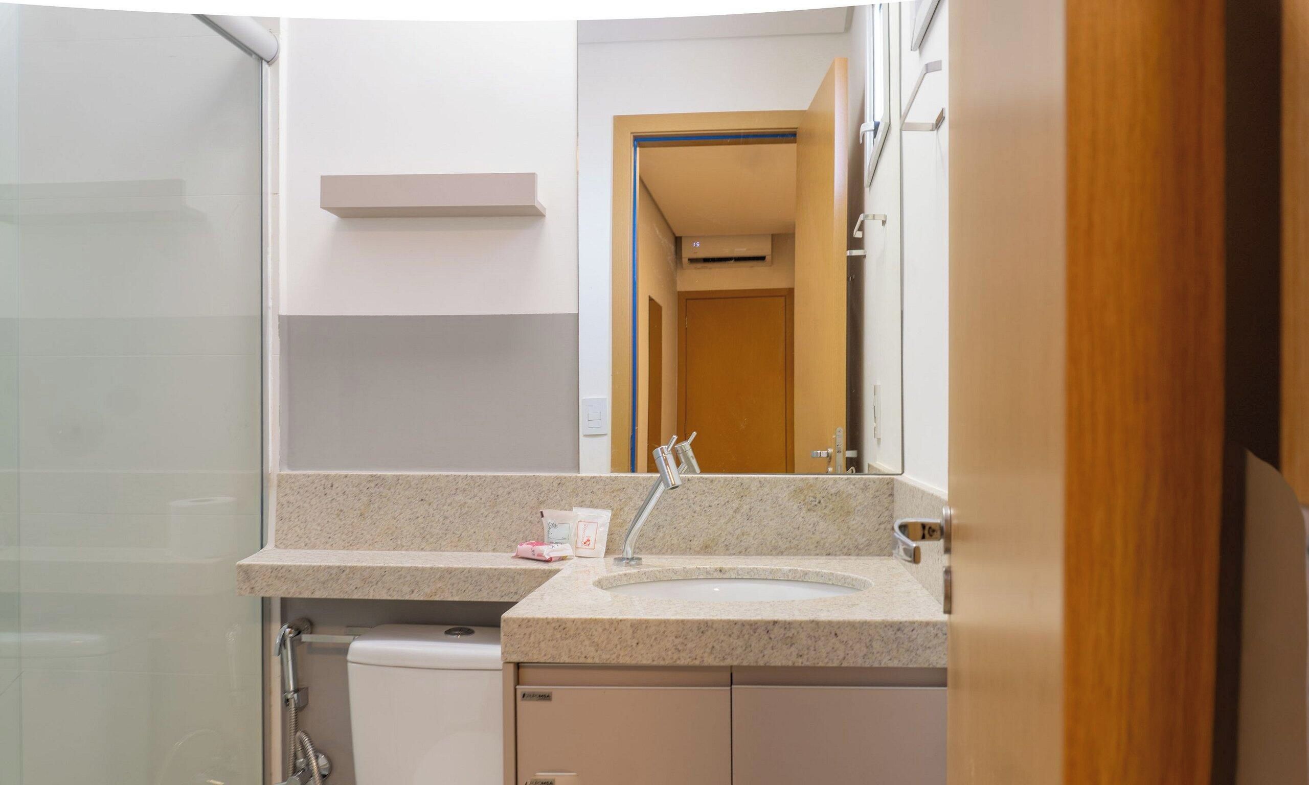 A bathroom with a sink, mirror, and shower.