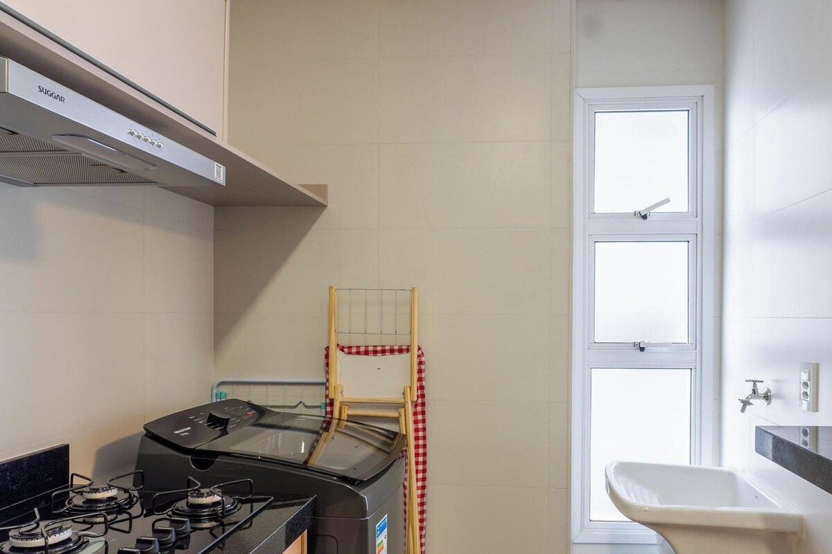 A compact kitchen with a gas stove, a built-in oven, and a window with a view.