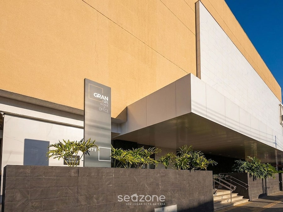 A modern building with a 'GRAN LIFE OFFICE' sign, a 'SEUZONE' sign, and a staircase leading to an entrance.