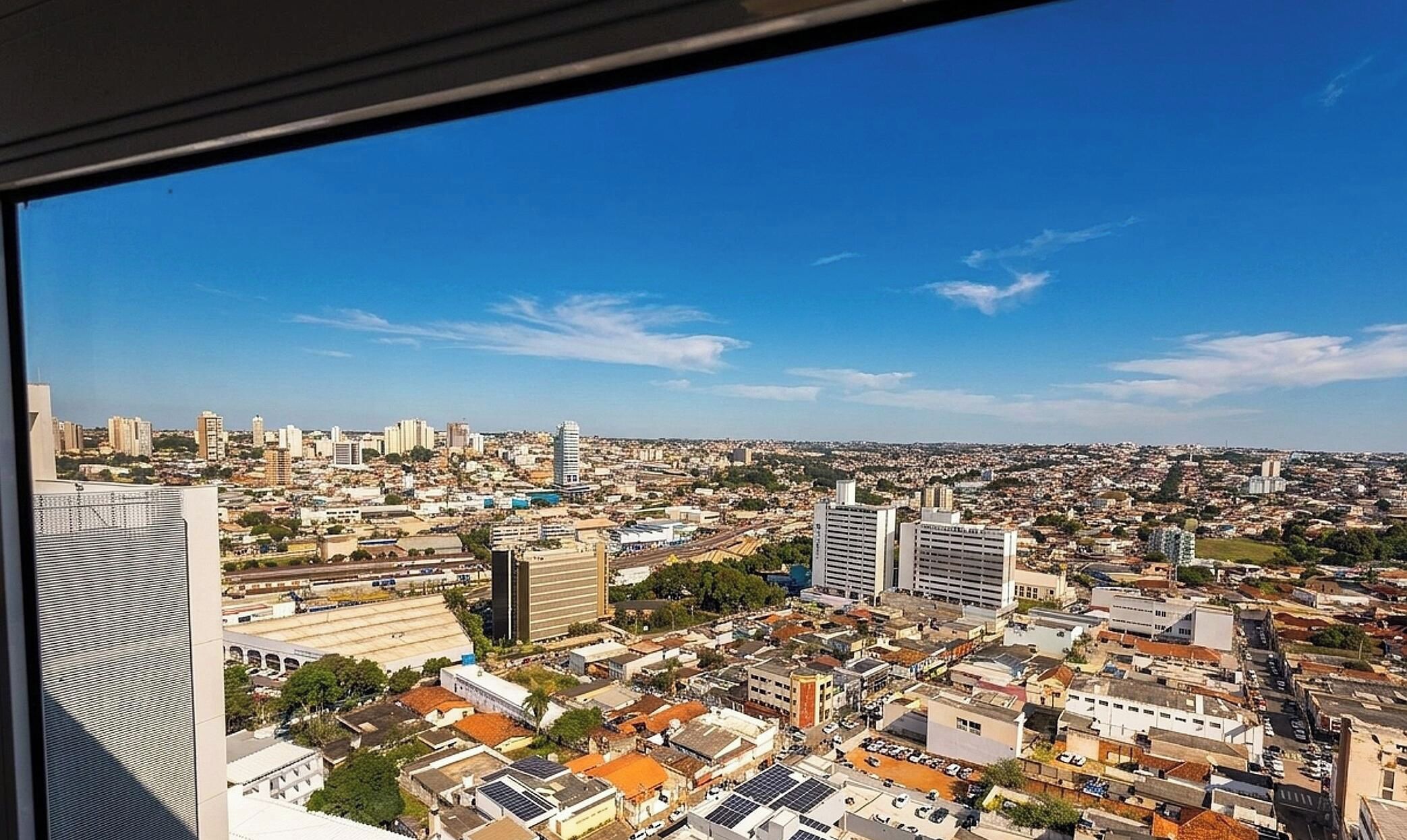 A cityscape with high-rise buildings, a mix of residential and commercial structures, and a clear blue sky.