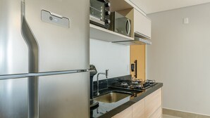 Une cuisine moderne équipée d’un réfrigérateur en acier inoxydable, d’un four encastré et d’une cuisinière à gaz.