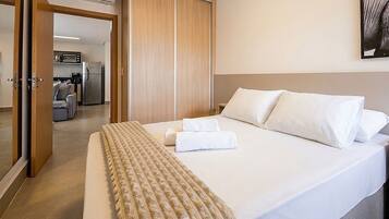 Habitación de hotel con cama, armario, kitchenette y baño.