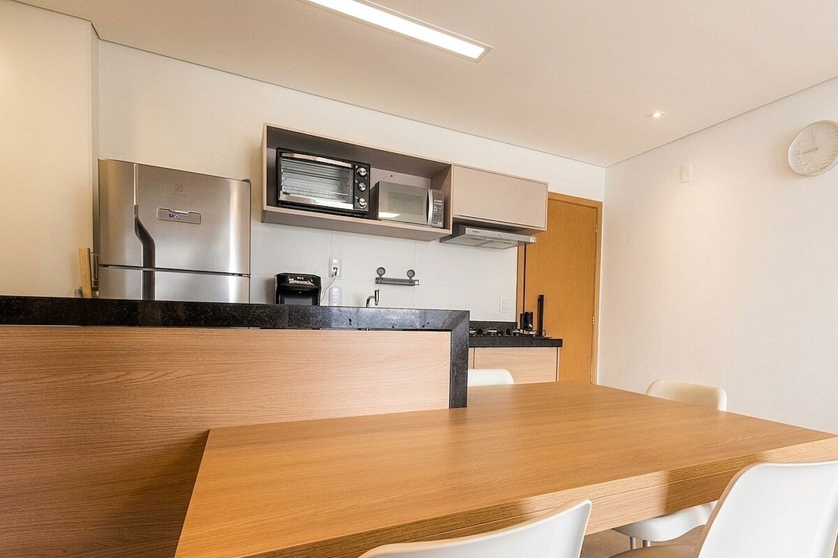 A modern kitchen with a built-in oven, microwave, and coffee maker.