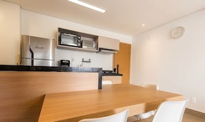 A modern kitchen with a built-in oven, microwave, and coffee maker.