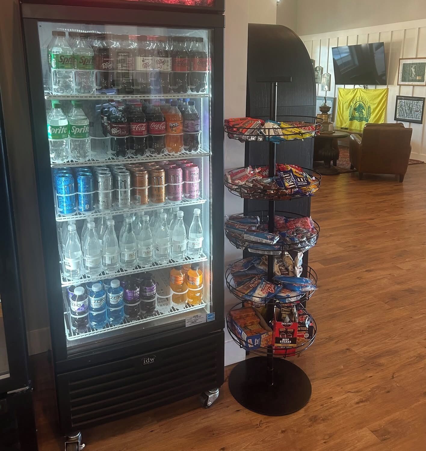A vending machine stocked with various beverages and snacks, including sodas, energy drinks, and packaged foods.