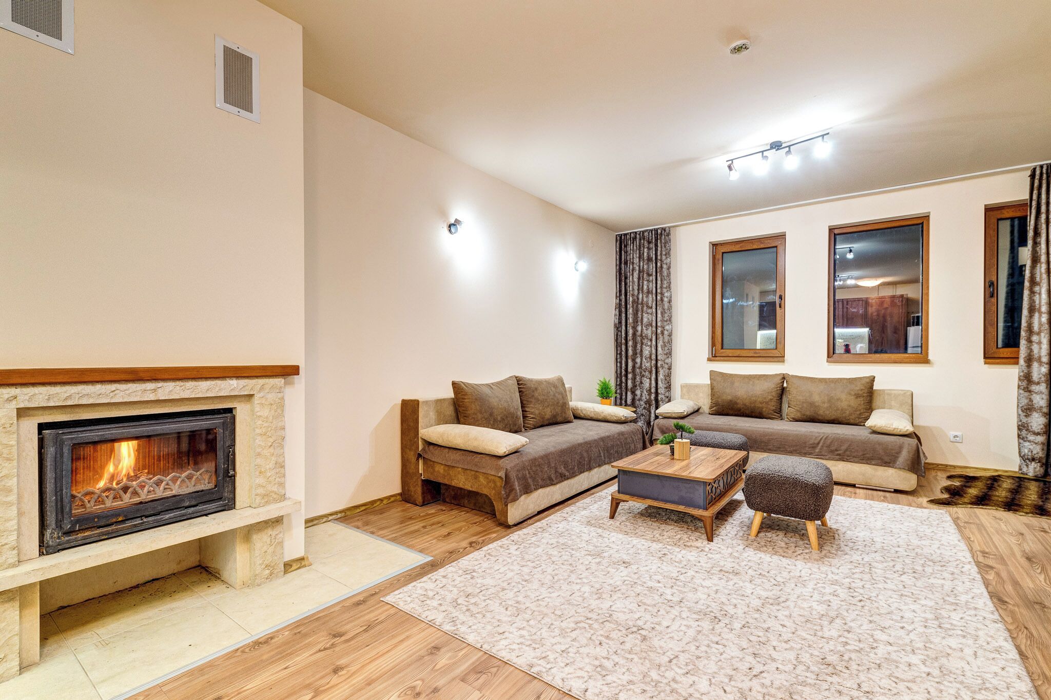 A living room with a fireplace, two sofas, a coffee table, and a rug.