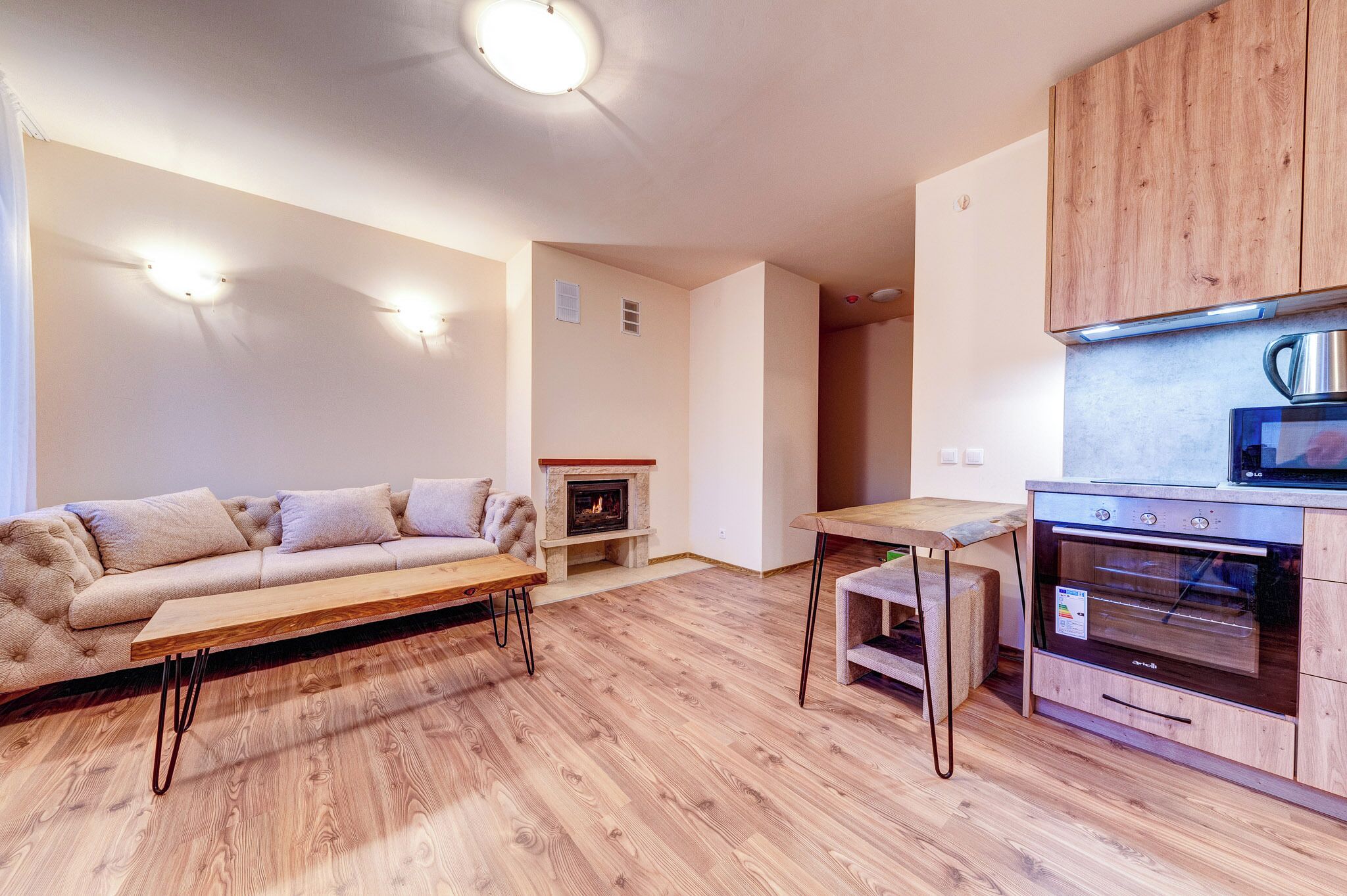 Un salon moderne avec un canapé, une table basse en bois et une cheminée.