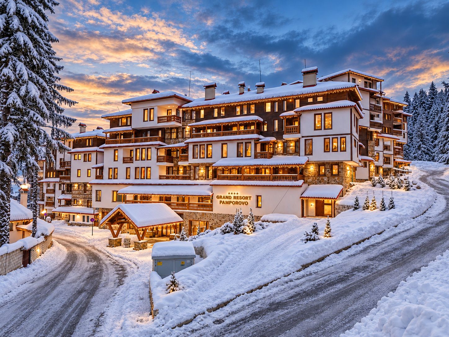 A multi-story hotel with a snow-covered exterior, a visible sign indicating it is a resort, and a paved driveway leading to the entrance.