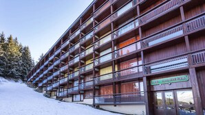 A multi-story wooden building with balconies, a sign reading "LES LAUZIÈRES," and a snowy landscape. - Holiday Home in Charvet With Ski Access (Bourg-Saint-Maurice)