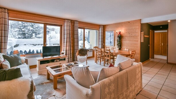 A cozy living room with a TV, sofa, and dining area. - Pistes du Soleil C1 - Four Bedroom Apartment, Sleeps 8 (Le Grand Bornand)