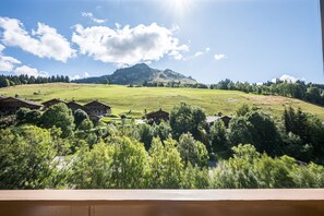 A rural landscape with a hill, houses, and trees.