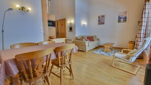 Una sala acogedora con una mesa de comedor de madera, sillas, un sofá y un sillón reclinable.