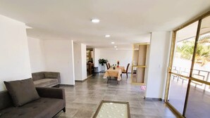 A spacious living area with a sofa, a coffee table, and a dining table in the background. - Private pool, garden, 4 bedrooms, parking FIFA2026 (pets welcome) (Cuernavaca)