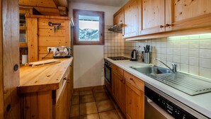 Una cocina con armarios de madera, una ventana, un lavaplatos y un lavamanos.