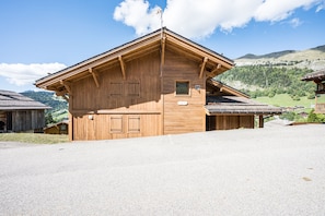 Un chalet en bois avec un toit en pente, une petite fenêtre et une plaque de pierre.