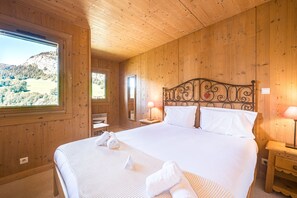 Une pièce en bois avec un lit, une fenêtre et une vue sur un paysage.