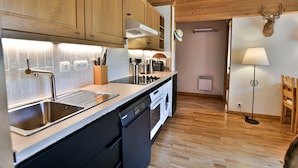 Una cocina con armarios de madera, lavavajillas, fregadero y un techo decorado con un ciervo.