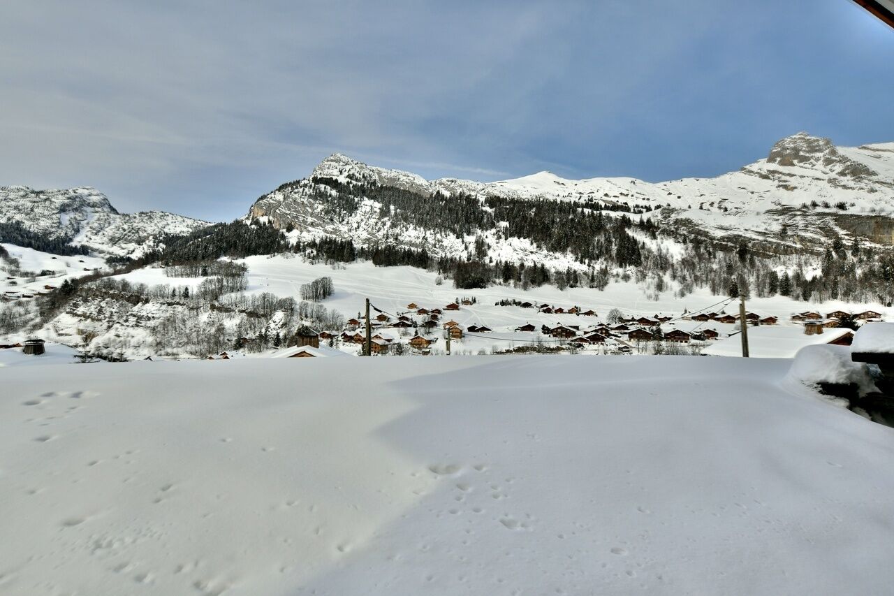 A snowy mountain landscape with a village in the valley.