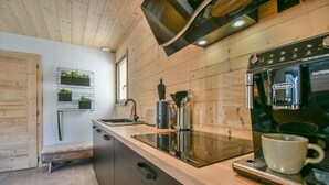 Une cuisine moderne avec des meubles en bois, une cuisinière encastrée et une machine à café.