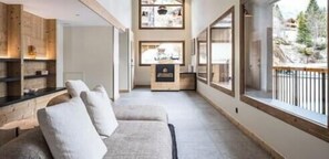 A modern interior with a sofa, wooden shelves, and a view through large windows.
