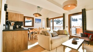Ein gemütliches Wohnzimmer mit einer Couch, einem Couchtisch und einem Essbereich mit Tisch und Stühlen.