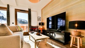 Ein gemütliches Wohnzimmer mit einer Couch, einem Couchtisch, einem Fernseher und einer Holzkommode.