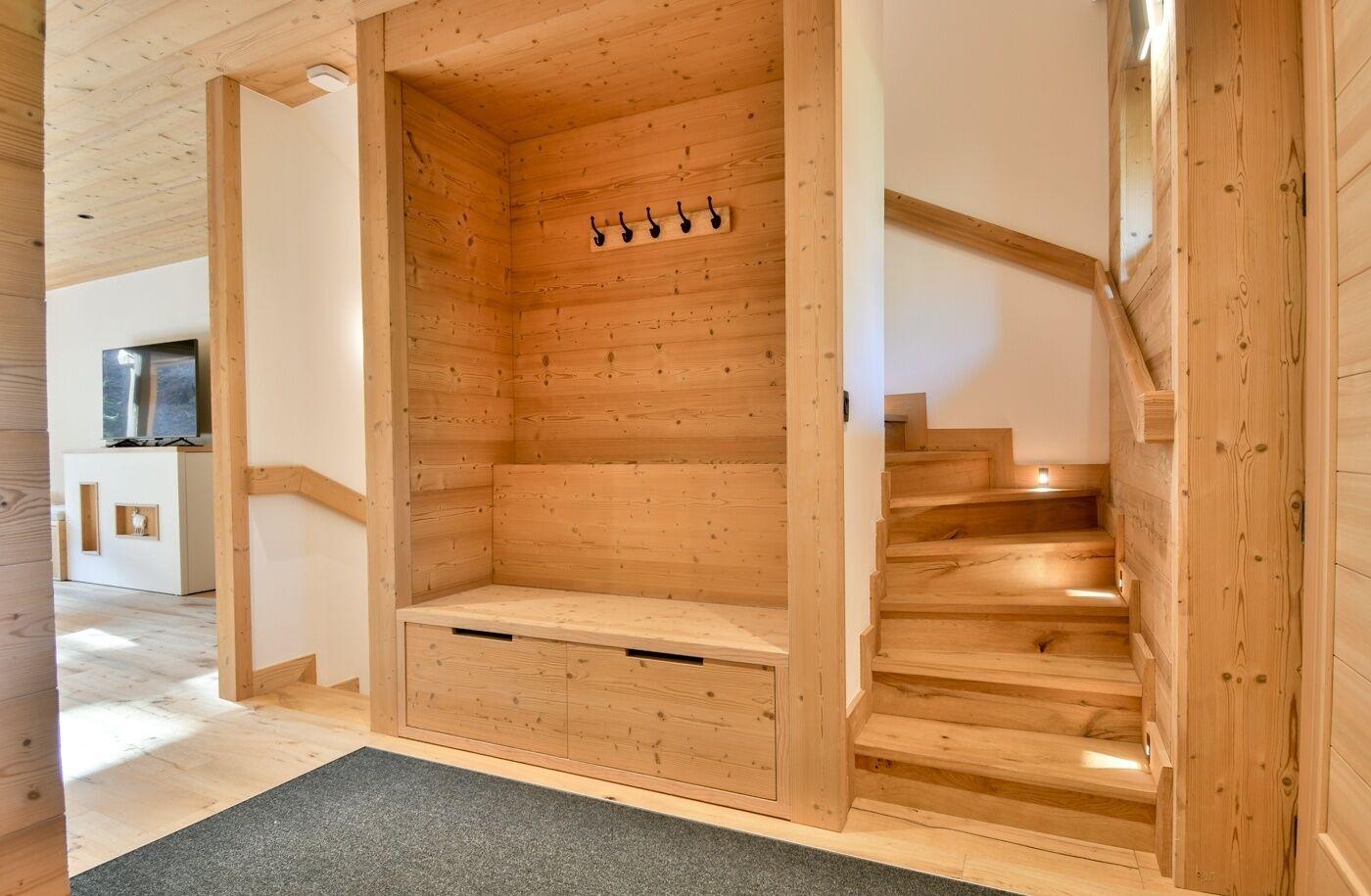 Ein Holzinnenraum mit einer eingebauten Bank und einer Treppe.