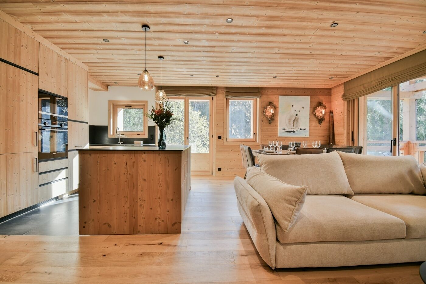 Une cuisine spacieuse avec des meubles en bois, un îlot central et des luminaires suspendus.