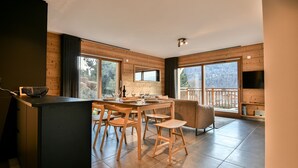 Una cocina moderna con detalles de madera, ventanas amplias y un comedor con vistas.