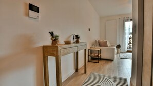 A modern living room with a wooden console table, a sofa, and a small side table. - Le Sève - B103 - One Bedroom Apartment, Sleeps 5 (Samoëns)