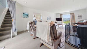 Une chambre spacieuse avec un grand lit, un bureau, une télévision et une vue sur l’extérieur.