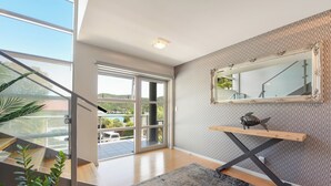 Een modern interieur met een trap, een grote spiegel en uitzicht op de omgeving.