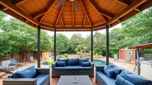 A covered outdoor patio with wicker furniture and a ceiling fan. - Pool, Games & BBQ Luxury Texas Home 4 bedroom (San Antonio)